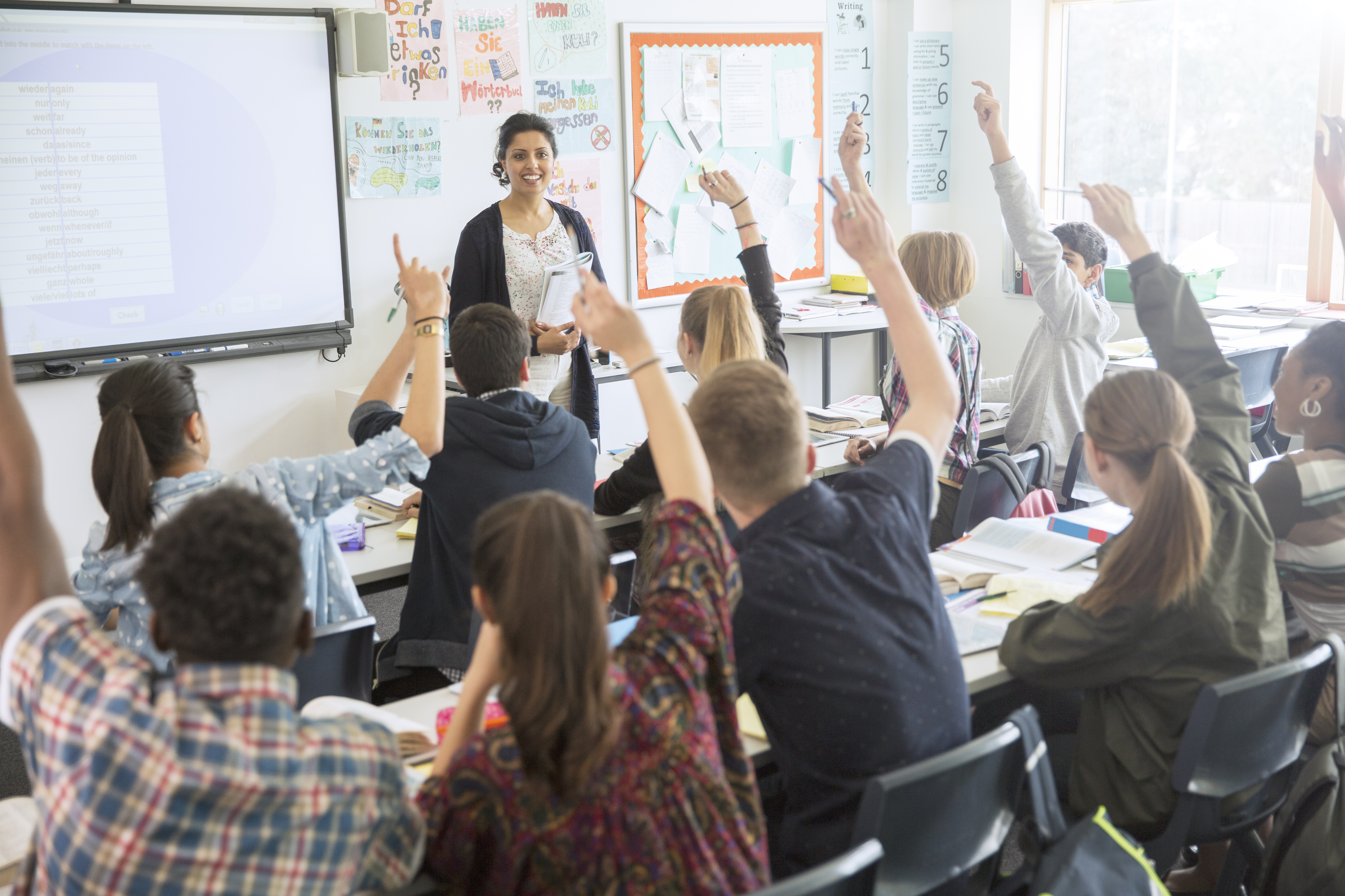 Classroom of Students with their hands raised